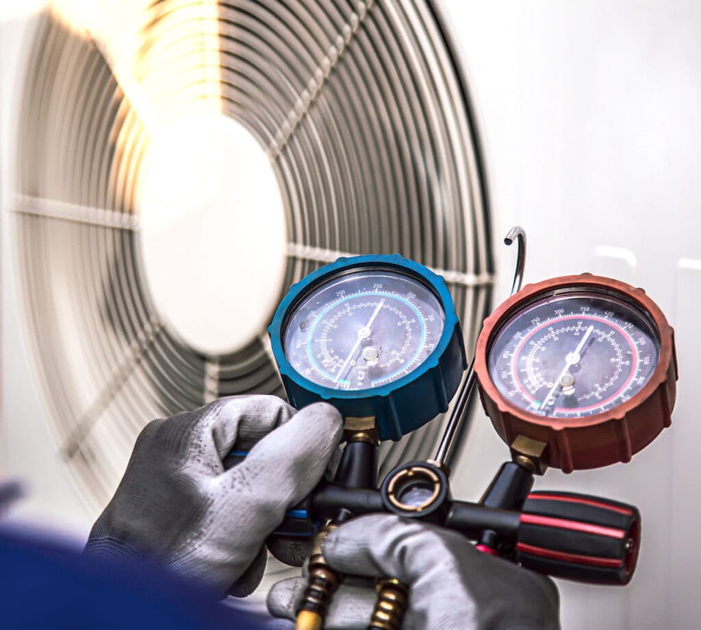 air conditioner technician using manifold gauge