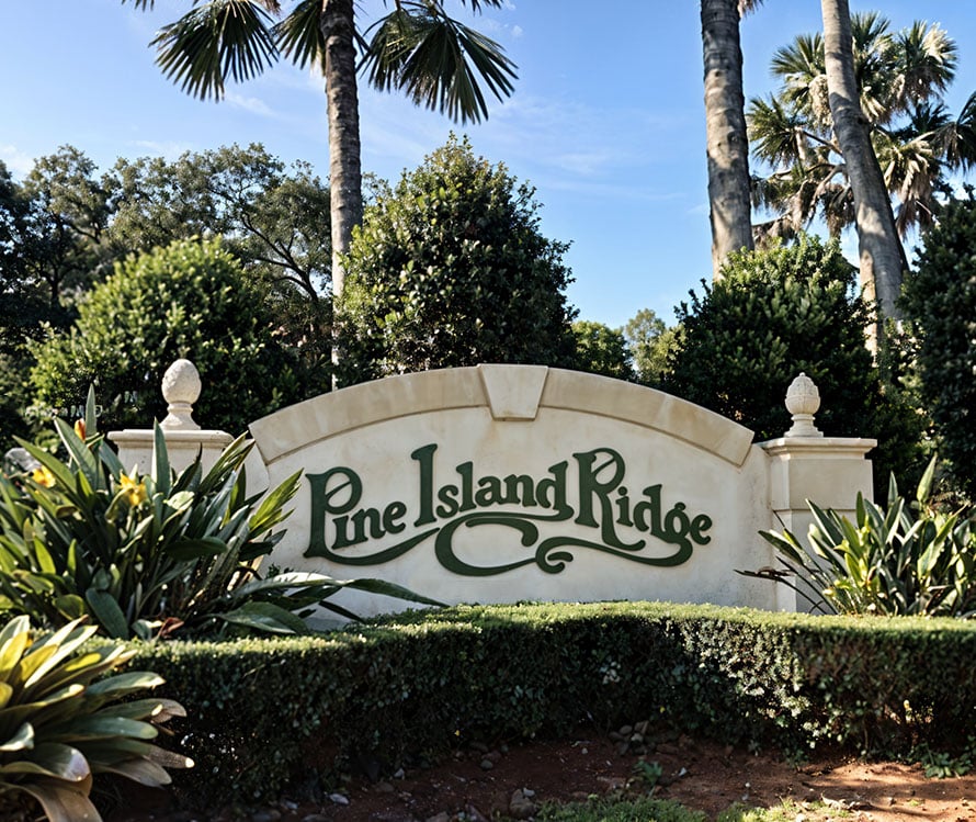 a Pine Island Ridge sign with a hedge and trees